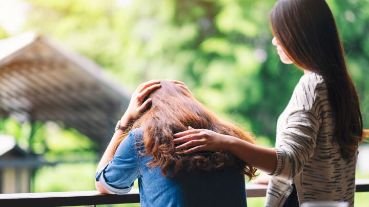 A woman comforting and giving encouragement to her sad friend