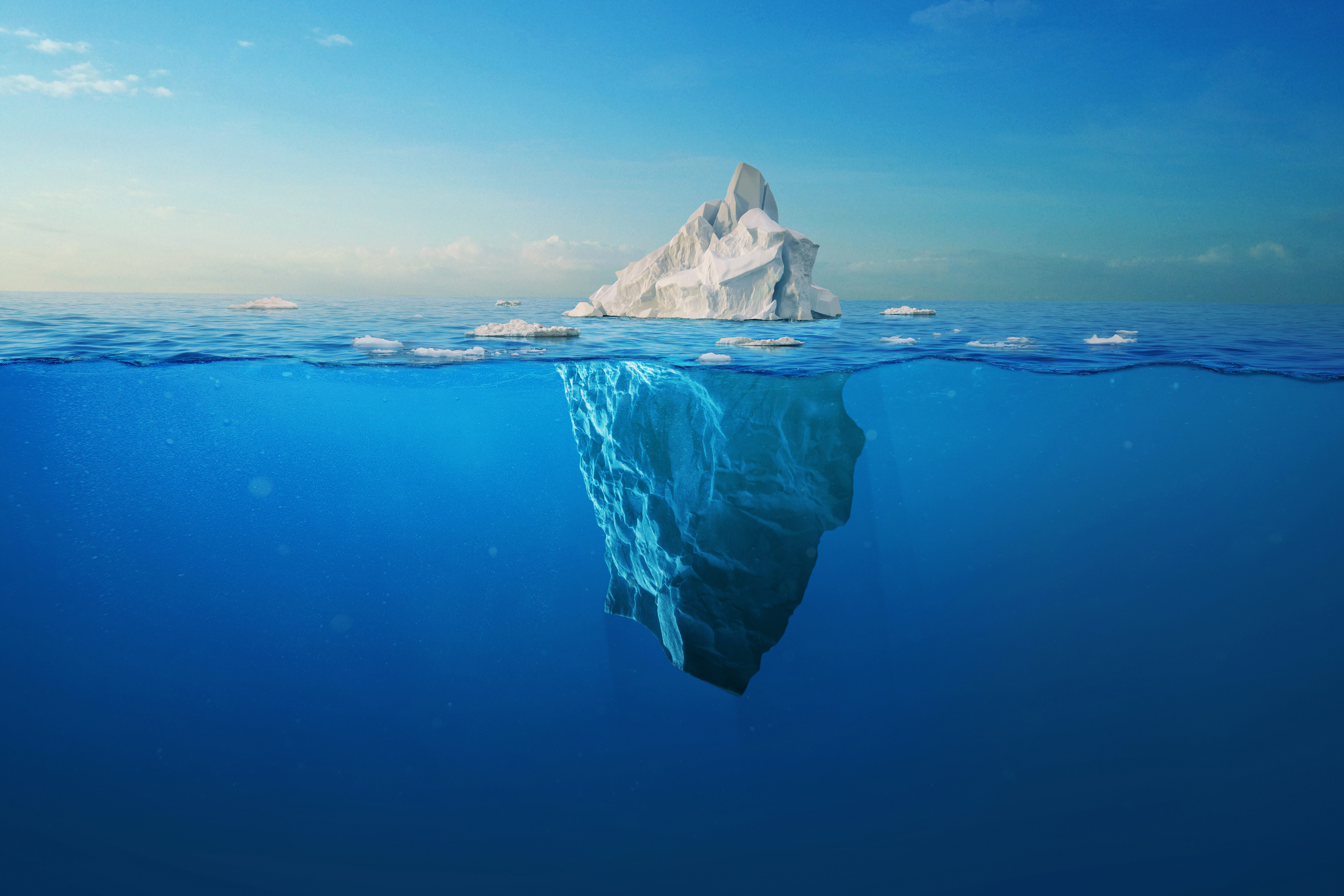 white iceberg floats in the ocean with a view underwater