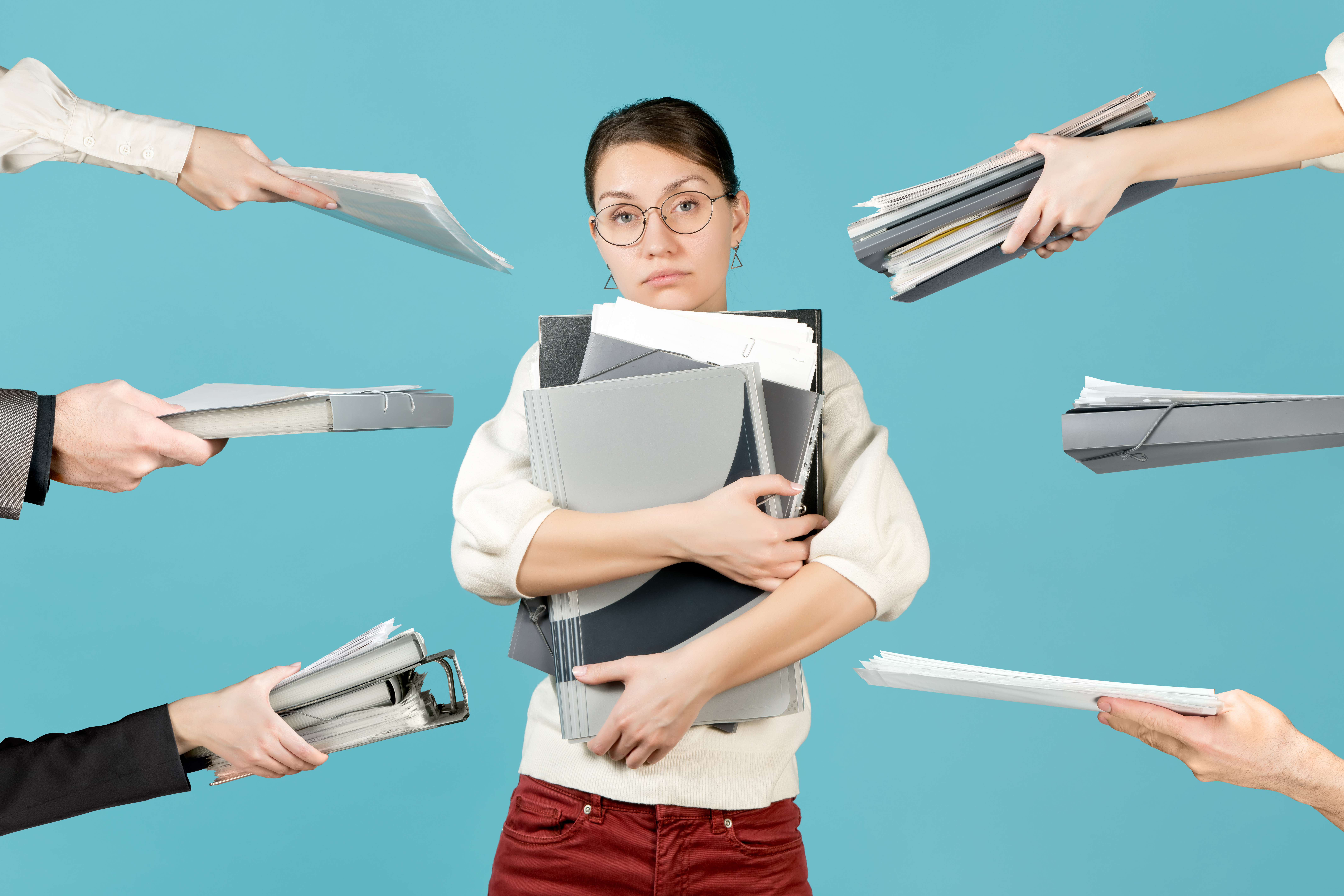 A sad girl holds a bunch of documents in her arms