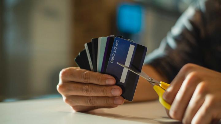 man cutting up credit card with scissors