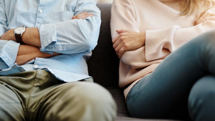 couple sitting on couch arms crossed