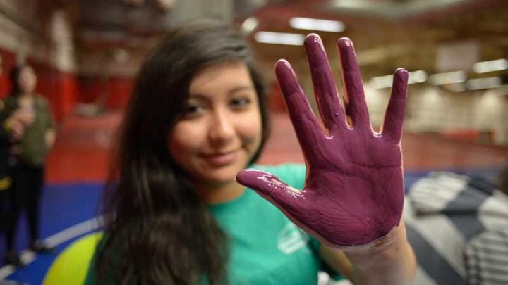 family bridges volunteer showing hand covered in purple paint