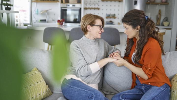 mother daughter talking on couch