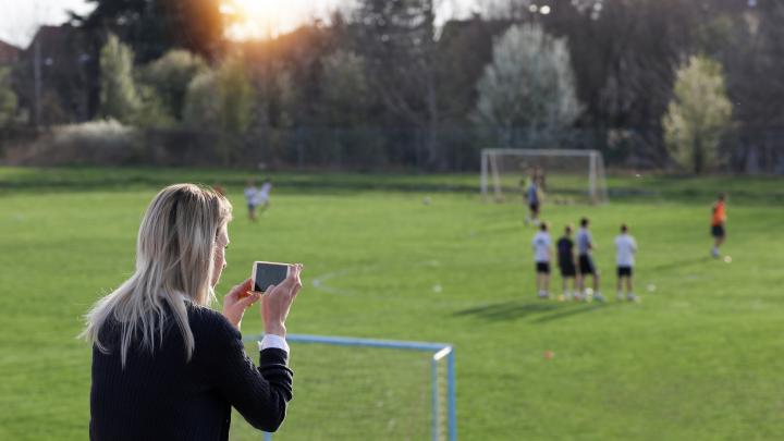 Mom taking photo of kids game