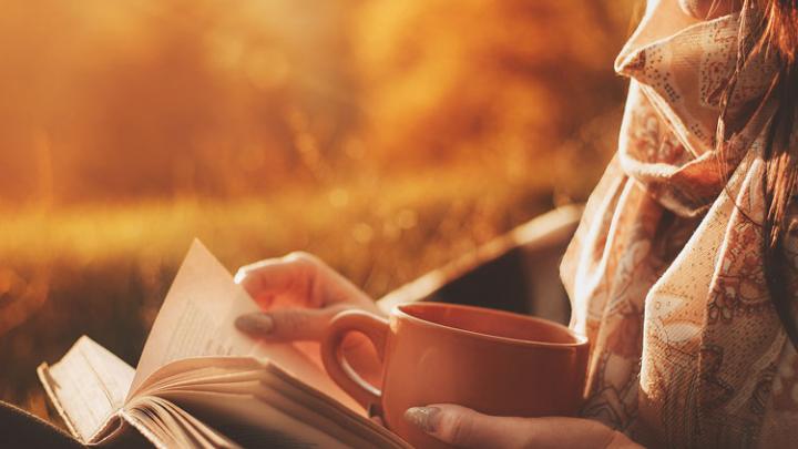 woman reading with cup of coffee