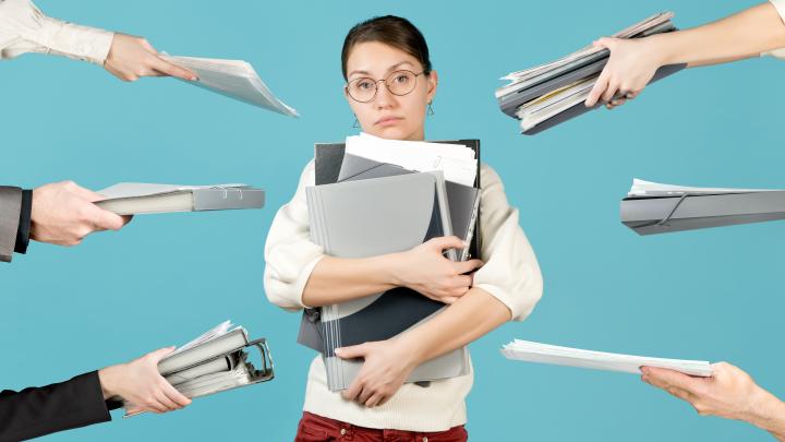 A sad girl holds a bunch of documents in her arms
