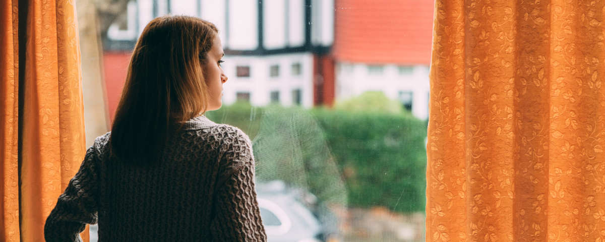 stuck at home now what, woman looking outside of window