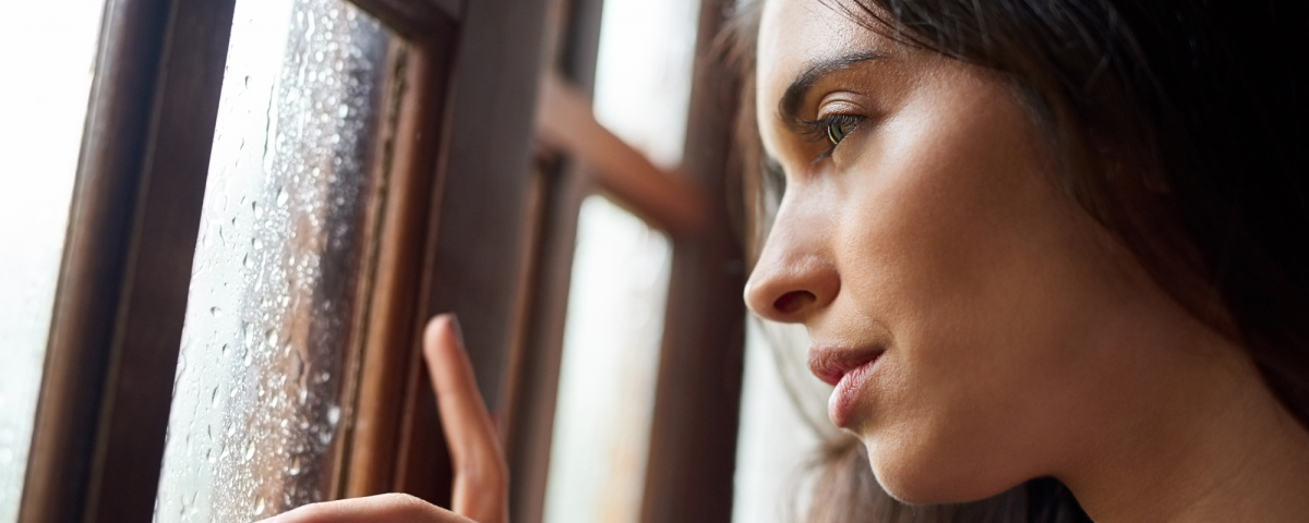 tips for dealing with uncertainty from COVID, woman staring out window on a rainy day