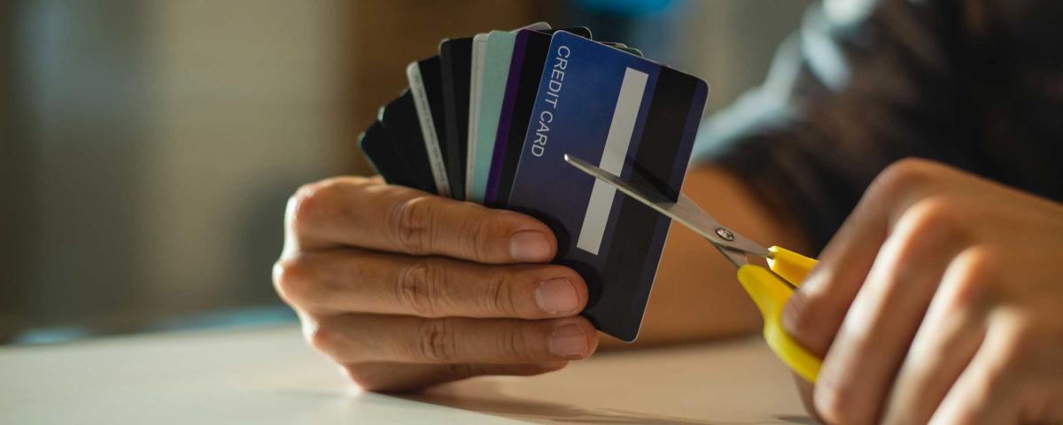 man cutting up credit card with scissors