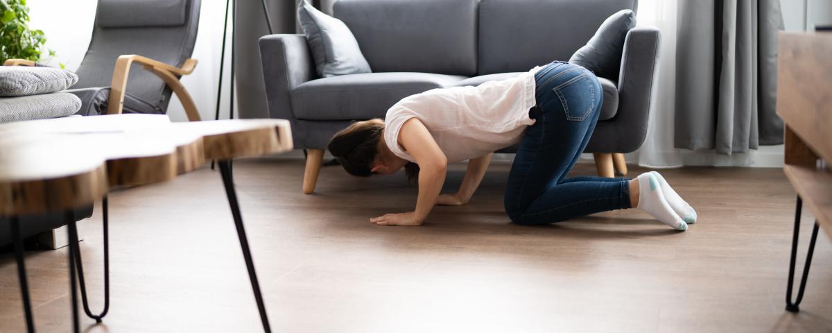 woman looking under couch