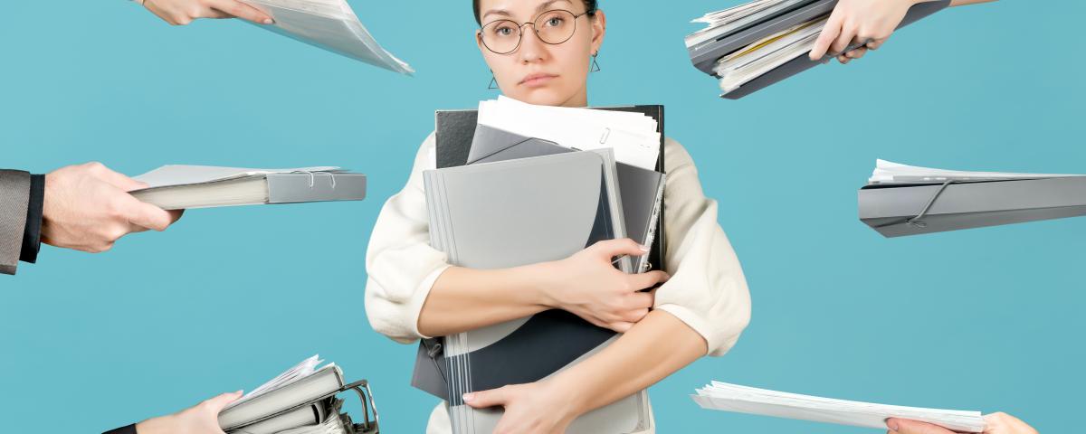 A sad girl holds a bunch of documents in her arms